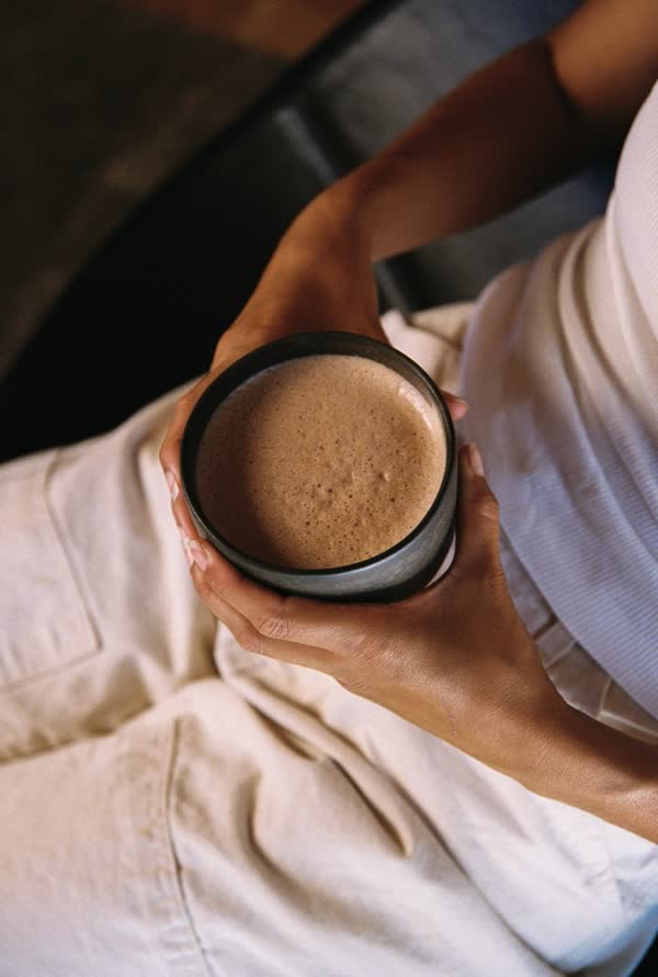 A warm cup of Ascend Cacao held in both hands